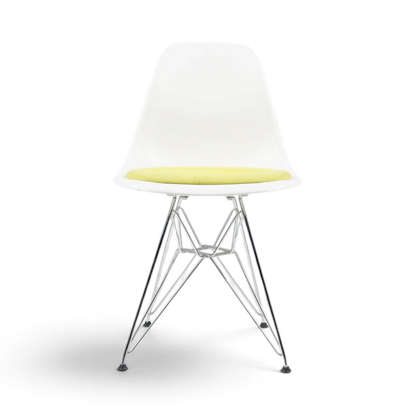 Eames Plastic Chair fra Vitra med hvitt skall og grønn sittepute, sett skrått forfra