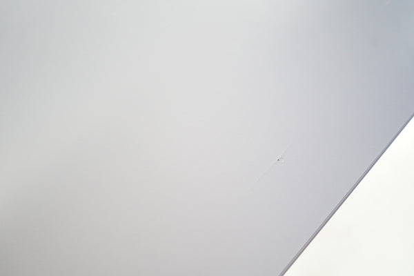Close-up of the white laminate surface of a Loopr AS bar table showing the integrated cable port detail.