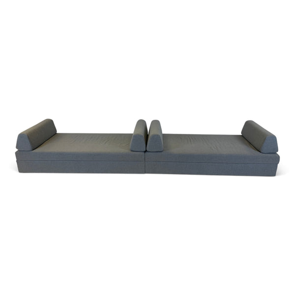 Refurnish by Loopr grey fabric sofa bed in flat sleeping position, featuring a minimalist design for guest rooms.