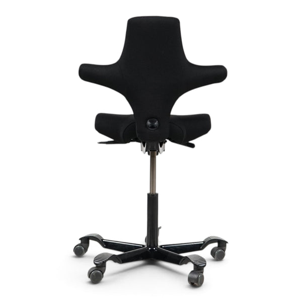 Refurnish by Loopr HÅG Capisco 8106 ergonomic office chair with black saddle seat and black five-star base, rear view.