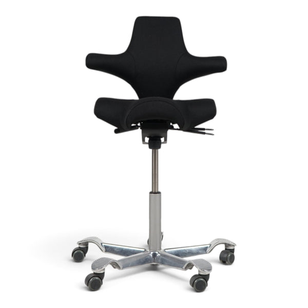 Refurnish by Loopr HÅG Capisco 8106 ergonomic office chair with black saddle seat and silver base on white background